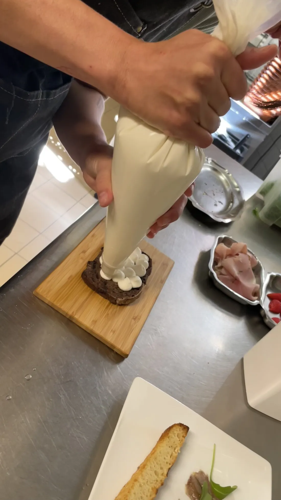 La crème pochée à la douille sur le pain au charbon végétal